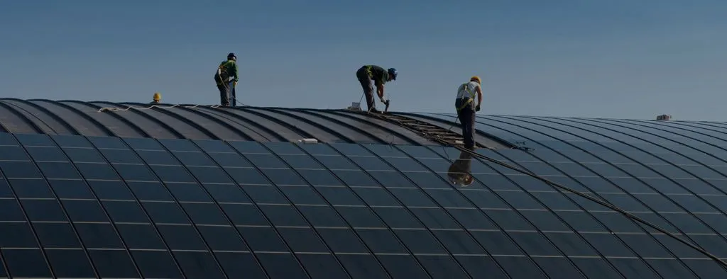 Operatori al lavoro su una copertura industriale curva con fotovoltaico integrato